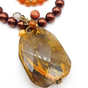 Brown beaded necklace with stone pendant